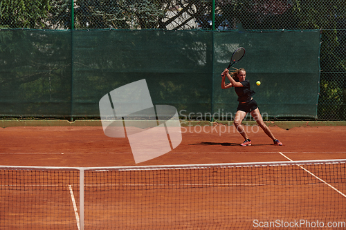 Image of A young girl showing professional tennis skills in a competitive match on a sunny day, surrounded by the modern aesthetics of a tennis court.