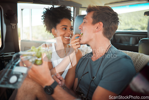 Image of Road trip, grapes and couple eating in van on travel journey, holiday or countryside date with love, care and diversity, Friends camper people and farm fruit food for healthy lifestyle in a caravan