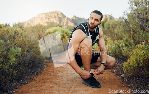 Image of Fitness, nature and man tie shoes before start of marathon training, exercise or health workout in USA Hollywood Hills. Sports, dirt path and runner ready for peace, freedom or wellness cardio run