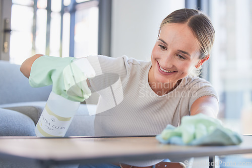 Image of Cleaning, spray and dust with woman and table surface at home for hygiene, domestic service or hospitality with gloves. Smile, housekeeping and cleaner washing furniture counter in living room