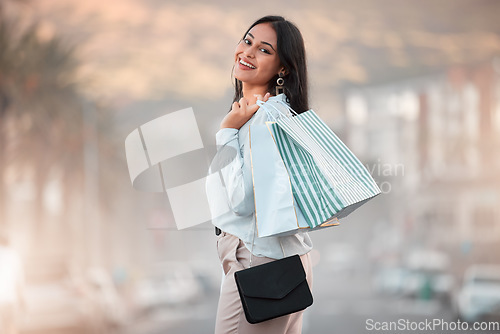 Image of Fashion, style and shopping bags with a woman out on an urban city street enjoying a spending spree. Stylish and rich arab female customer or tourist happy after buying items on discount sale