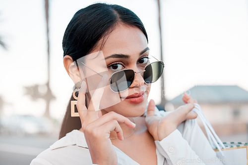 Image of Face, fashion and woman in sunglasses with shopping bags in city for designer clothing in mall or boutique. Portrait, wealth or rich woman smile or retail customer from Brazil in cool stylish glasses