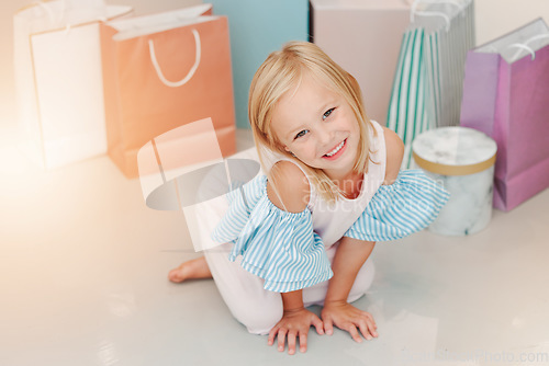 Image of Birthday, gift or present with girl child portrait for fashion, boutique and luxury lifestyle. Kid on floor with shopping bags, young retail customer for children discount, clothes sale marketing