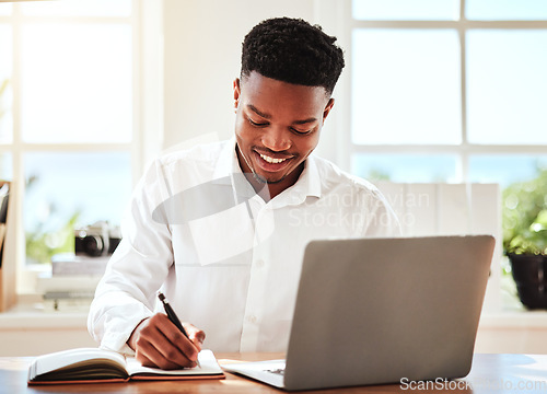 Image of Internet, laptop and black man writing in notebook, happy freelance worker. African businessman with smile doing online research, taking notes for startup idea or project at desk and in modern office