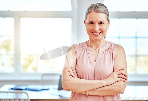 Image of Female leader, manager and boss in an office boardroom for design standing arms crossed while looking confident. Portrait, management and startup with a mature business woman in an office in England