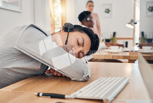 Image of Tired call center worker sleeping at desk, burnout from working at telemarketing company and stress from consulting with people online on computer. Customer service employee with sleep problem