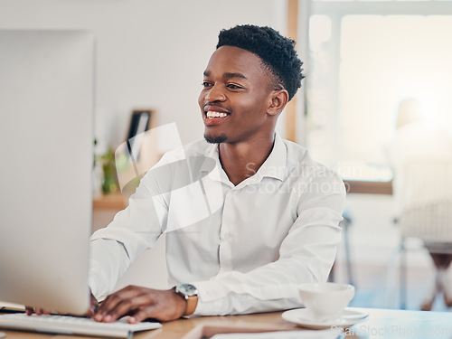 Image of Computer, typing and black man working in the office, doing research and writing emails. Technology, work and businessman with smile on face in workspace for innovation, internet and startup company