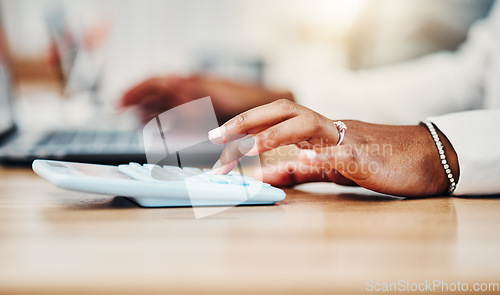 Image of Accountant doing budget planning, money and finance management and bookkeeping or tax. Black woman using calculator, laptop and financial accounting at her desk in a corporate office closeup.