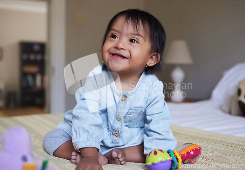 Image of Down Syndrome, smile and happy baby relax on bed having fun, play with toys and enjoy happiness at home. Intellectual disability, mentally disabled and child development for young toddler in bedroom