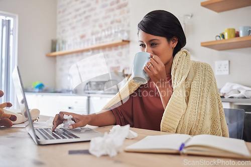 Image of Working from home, a woman sick with covid virus or flu and doing business email with laptop on the kitchen table. Remote office work, online employee has tea and blanket to stay warm in poor health