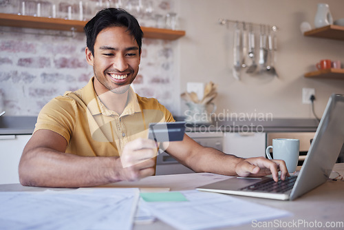 Image of Finance, laptop and credit card with a man doing accounting or household budget from the kitchen of his home. Ecommerce, savings and investment with a male working on wealth management for the future