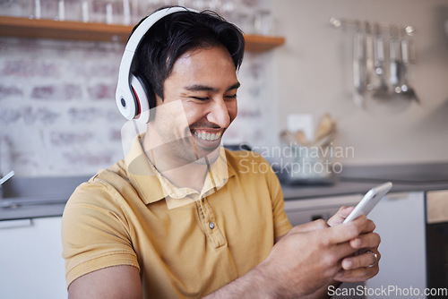 Image of Phone, music and man on social media laughing at a funny joke on a podcast, network app or video streaming website. Smile, meme and happy Asian person sharing trendy online content to relax at home