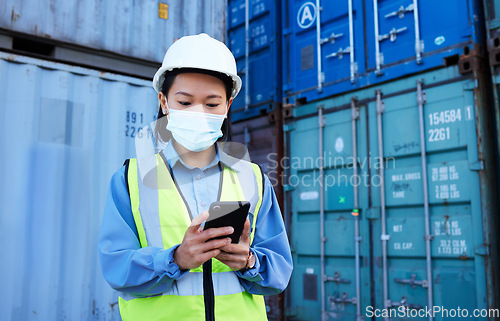 Image of Covid, supply chain logistics and phone with a woman shipping worker managing an online order on a container dock. Stock, freight and cargo with a female courier at work on a smartphone for export