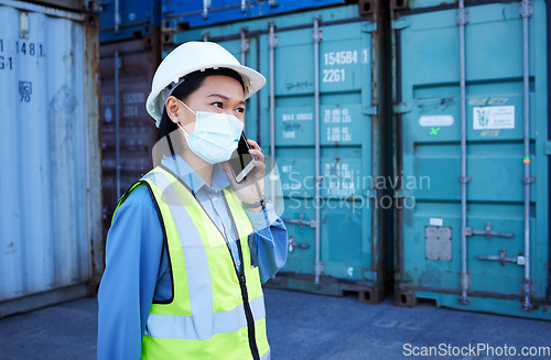 Image of Covid, phone and supply chain logistics with a woman shipping worker on a call while on a commercial container yard. Freight, cargo and communication with a female courier at work with export storage