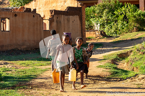 Image of Morning ritual in Lakanga village as Malagasy girls fetch water for cooking. Andringitra mountain, Madagascar