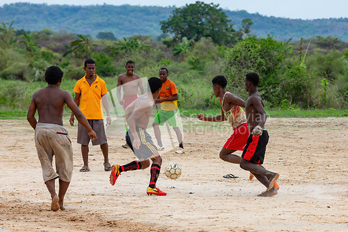 Image of A group of young men play soccer on a dirt field in Bekopaka, Madagascar