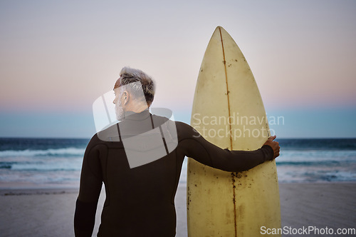 Image of Beach, man and surfboard with back view for morning cardio fitness and tranquil swim in nature. Senior surfer waiting for low tide at ocean for calm surf waves with peaceful sky at dawn.