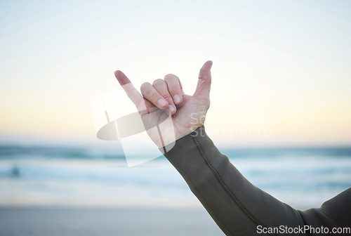 Image of Shaka, surf and sports with the hand sign of a man on the beach for surfing, fitness or exercise in the morning. Workout, training and health with a male surfer outdoor for wellness or cardio