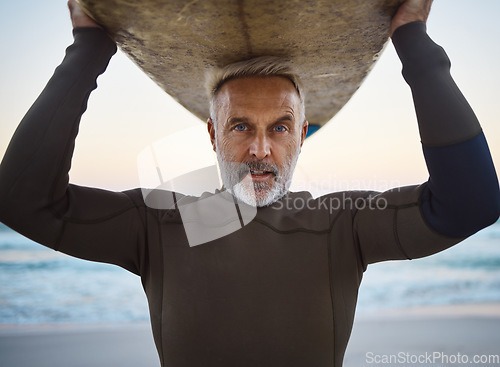 Image of Beach, surf board on head and a mature surfer man with ocean waves and sea sand. Freedom, water sports and fun on retirement holiday in Australia. Health, fitness and senior in wetsuit for surfing