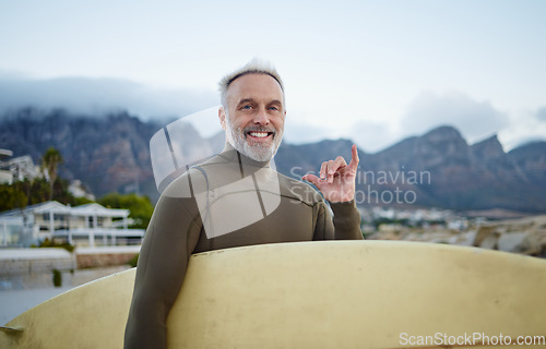 Image of Senior surfer, surfing at beach for fitness and exercise in retirement on an island travel holiday. Man swimming in Indian ocean on summer vacation, board to surf waves on the sea and shaka hand sign