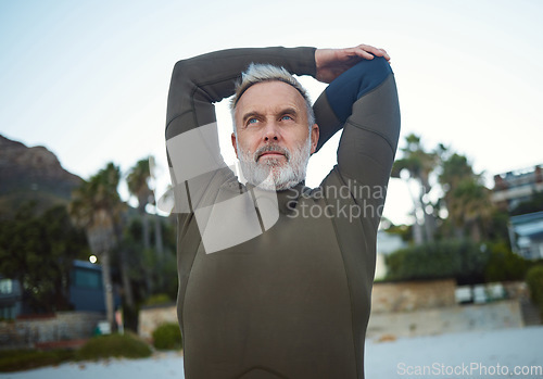 Image of Surf, fitness and stretching with a sports man getting ready for surfing, workout or training on the beach. Health, wellness and cardio with a mature male surfer preparing to start of his routine