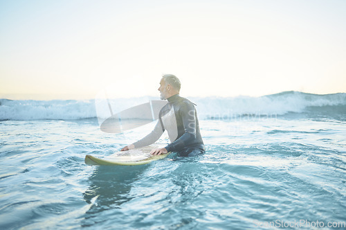 Image of Swimming, beach and old man in water surfing enjoying a summer holiday vacation his retirement in Los Angeles, USA. Fitness, healthy and senior person waiting for ocean waves on his surfboard at sea