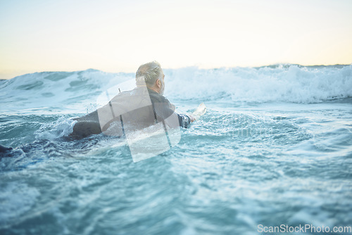 Image of Surf, sea and water sports with a mature man surfing, swimming and body boarding in the ocean while enjoying surfer trip for summer travel. Male athlete on his surfboard in the ocean for Bali holiday