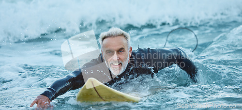 Image of Surf, sea and sports with a mature man surfer in the water for sport, fitness and surfing during summer. Training, workout and exercise with a male athlete on his surfboard in the ocean alone