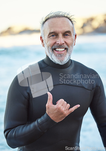 Image of Elderly, surfer and beach with hand sign for portrait with smile in summer by ocean for wellness, fitness and health. Senior, man and surf by sea in retirement on vacation, holiday or travel to Miami
