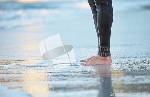 Image of Surf, water and legs of man on the beach for fun adventure, fitness and exercise workout in Rio de Janeiro Brazil. Sand, wellness peace and feet of surfer with wetsuit for sports surfing in ocean sea