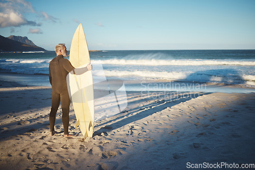 Image of Beach, board and man surfing on holiday in the summer water of Brazil during retirement freedom. Back of mature surfer on travel vacation by the ocean on an island for the waves with his surfboard