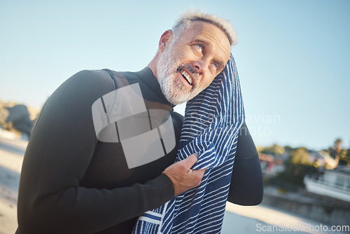 Image of Surfer, towel and swimming with senior man drying hair after a swim, surf and water sports while on a surfing trip, adventure and summer vacation. Happy male smiling in a wetsuit while on holiday