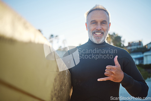 Image of Beach, surf board and a happy elderly surfer man with hand sign and smile. Freedom, water sports and happiness, fun on retirement holiday in Australia. Health, fitness and senior ready for surfing.