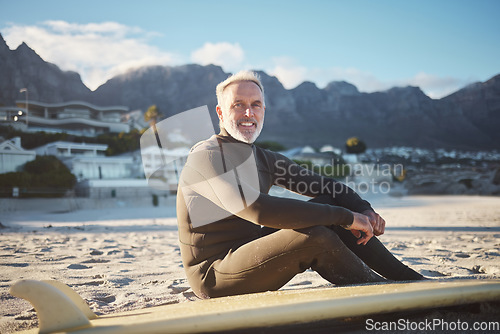 Image of Surf, sports and sand with a mature man on the beach for surfing, fitness and exercise while on summer holiday. Workout, training and health with a surfer and his surfboard enjoying retirement travel
