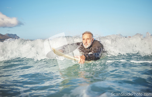 Image of Ocean waves, senior man surfing on beach and healthy fitness lifestyle in Australia summer holiday. Elderly surfer swimming with surfboard, sea water exercise and relax in retirement travel vacation