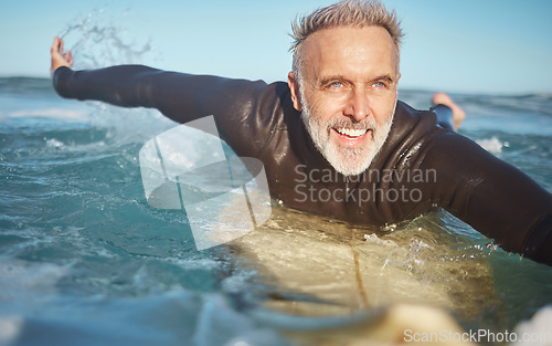 Image of Beach, water and old man surfer swimming on a summer holiday vacation in retirement with freedom in Bali. Smile, ocean and senior surfing or body boarding enjoying a healthy exercise on sea of Island