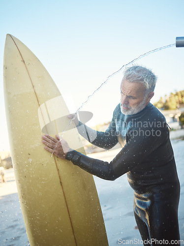 Image of Old man, beach and surfer cleaning surfboard, surfing in Mexico on summer holiday or vacation. Washing, shower and elderly retired male remove sand on board after surf or training exercise in ocean.