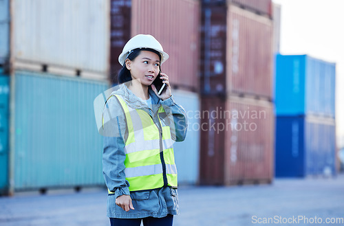 Image of Logistics, phone call and woman talking about shipping container on a phone while working at port. Asian insdustrial employee speaking about distribution of cargo and stock on a mobile at a warehouse