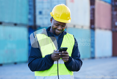 Image of Social media, logistics and employee working in shipping typing on a mobile app with phone at a port. Happy African warehouse man reading an email or communication on a smartphone at industrial site