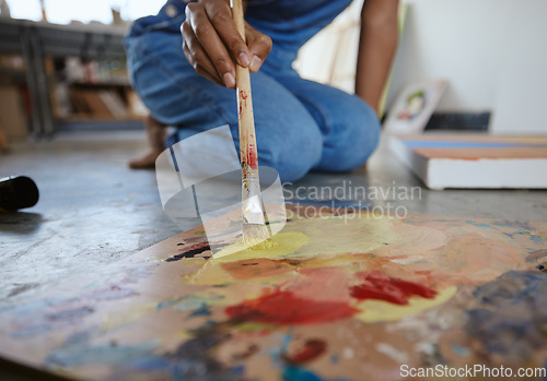 Image of Artist woman, painting and paint brush on art studio floor being creative and working with watercolor for artwork project. Talented, skill and canvas closeup with hand of a female painter in workshop