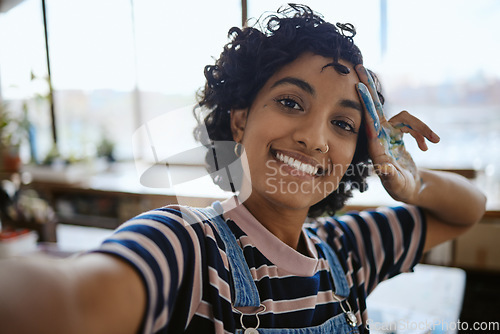 Image of Selfie, creative woman and painter in studio smile, relax and happy with completed work. Portrait, confident girl and female Indian artist with hand covered in oil paint, watercolor and at workspace.