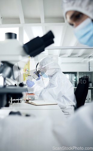 Image of Science, laboratory and scientist doing covid research on dna, rna and medical development with a microscope. Scientists in hazmat suits, face mask and safety gloves busy working experiment testing