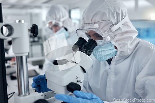 Image of PPE, covid and DNA scientist with microscope research for science innovation, investigation and development in a test laboratory. Biotechnology people with analysis or studying medical sample in lab