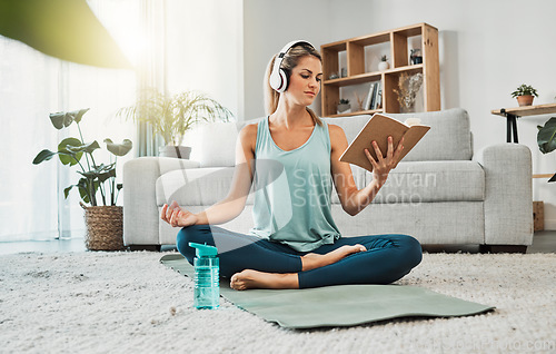 Image of Meditation yoga, calm music and woman reading a book while listening to podcast on the living room floor of a house. Girl training her mind with a book for knowledge, relax and peace in the lounge