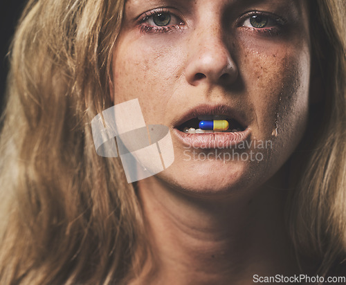 Image of Depression, portrait and girl with pill in her mouth with emotional tears on face from crying. Sad, unhappy and isolated woman with mental health problem taking psychiatry medicine closeup.