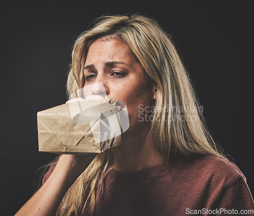 Image of Anxiety, scared woman breathing into paper bag on dark background for mental health or psychology mockup. Young girl experience fear, panic or asthma attack breathe air for stress, sad and depression