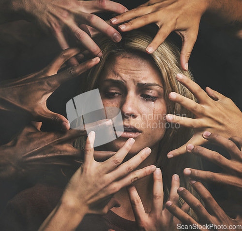 Image of Many hands, face and abuse with a woman victim feeling fear, alone or crying in studio on a dark background. Sad, pain and violence with a scared female suffering with stress or social anxiety