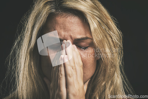 Image of Stress, anxiety and depression with a mental health woman suffering from a headache or migraine in a studio on a dark background. Cancer and sad young female covering her face in fear and distress
