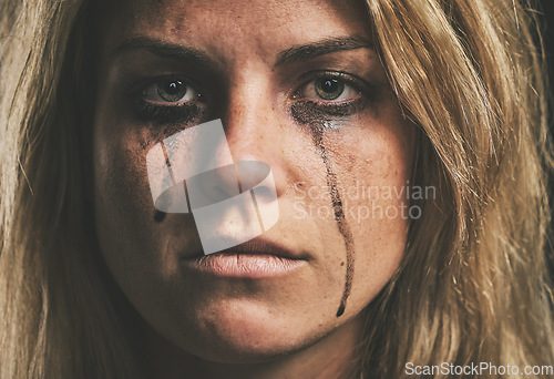 Image of Face, crying and domestic violence with a woman victim of abuse in studio with makeup closeup. Sad, fear and pain with a scared female feeling angry or emotional with grief, tears and problems