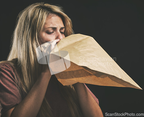 Image of Anxiety, breathing and scared woman with paper bag, mental health and emergency oxygen air for lungs on black background. Panic attack breathe problem, stress and fear of depression, nausea and sick